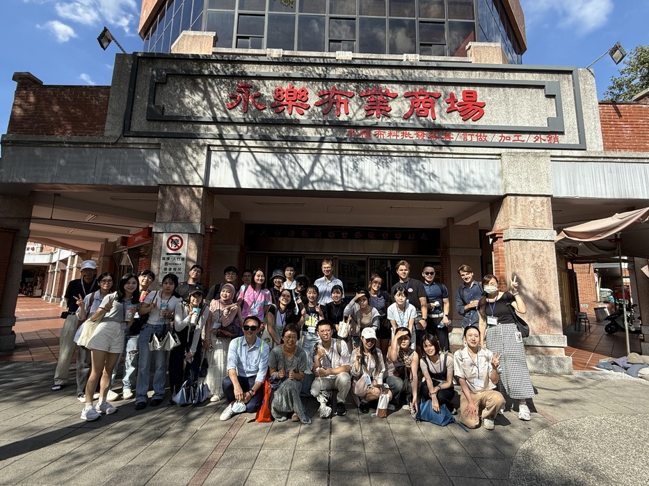 Professors and students pose for a group photo in front of Yongle Market.Image