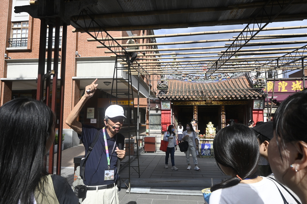 Professors and students listen to a guided explanation in front of the Xiahai City God Temple.Image