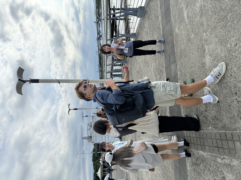 走讀導覽講師(右邊灰色上衣者)於大稻埕碼頭向學生解說今昔變化圖片